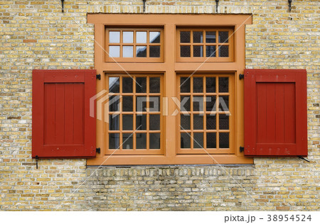 old red wooden window on brock wall 38954524