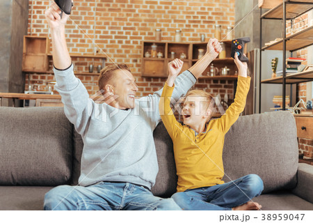 Joyful nice father and son expressing their Joyful nice father and son expressing their 38959047