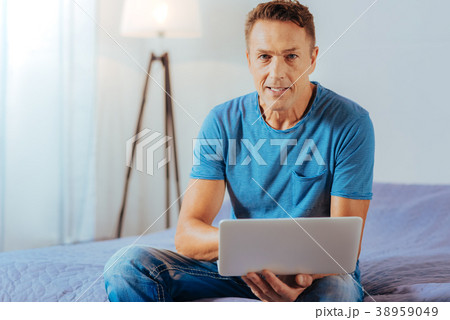 Positive handsome man holding a netbook Positive handsome man holding a netbook 38959049