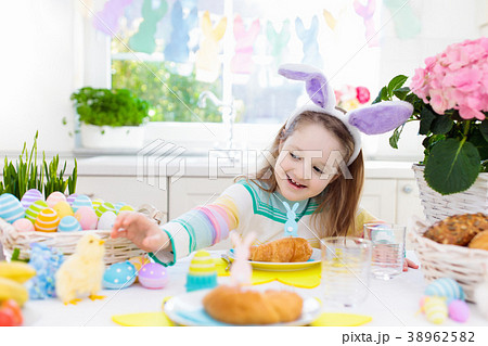 Kids at Easter breakfast. Eggs basket, bunny ears. 38962582