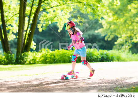 Child riding skateboard in summer park Child riding skateboard in summer park 38962589