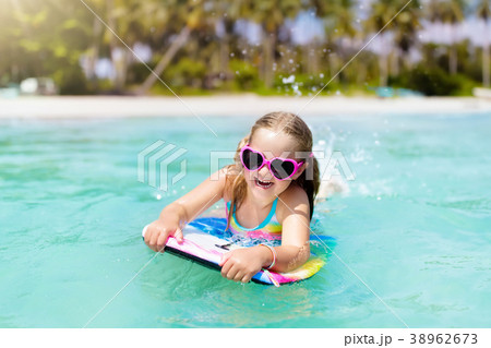 Kids surf on tropical beach. Vacation with child. 38962673