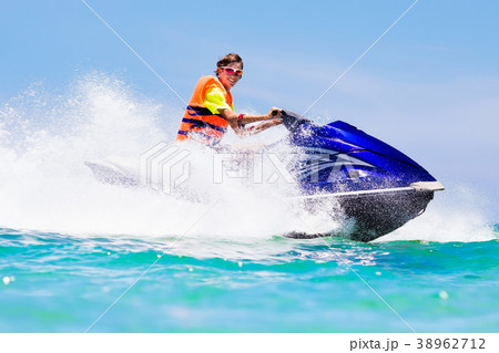 Teenager on jet ski. Teen age boy water skiing. 38962712