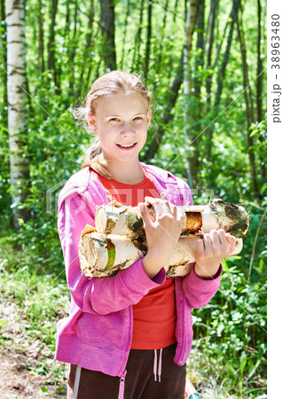 Young girl carries firewood from forest 38963480