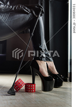 Female sexy legs with handcuffs and crop whip Female sexy legs with handcuffs and crop whip 38964031