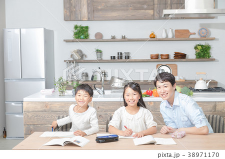 家族 父親 お父さん 姉弟 勉強 ダイニングキッチン ライフスタイル 宿題する小学生の写真素材
