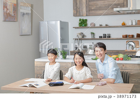 家族 父親 お父さん 姉弟 勉強 ダイニングキッチン ライフスタイル 宿題する小学生の写真素材