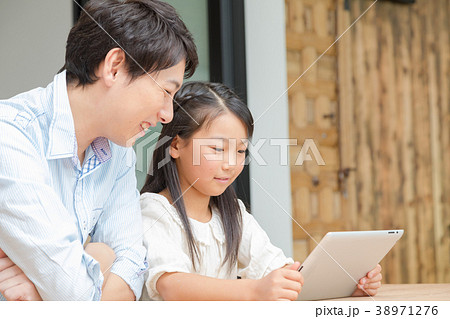 タブレット端末を操作する親子　父と娘　タブレットを見る親子　父親　お父さん　娘　女の子　生活感 38971276