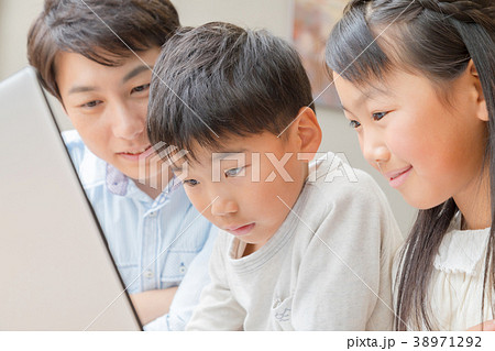 パソコンを使う家族　父親　お父さん　姉弟　勉強　ダイニングキッチン　ライフスタイル　宿題する小学生 38971292