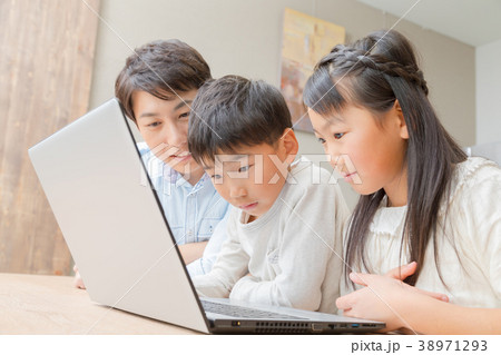 パソコンを使う家族 父親 お父さん 姉弟 勉強 ダイニングキッチン ライフスタイル 宿題する小学生の写真素材