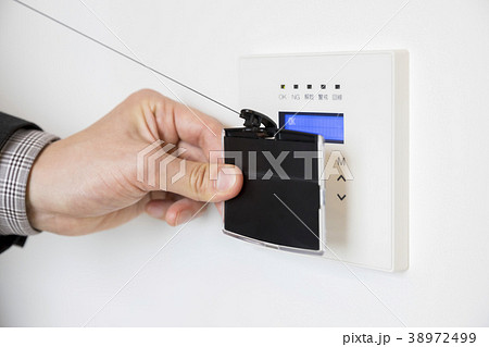 IDカードをかざしてドアロックを解除するビジネスマン 38972499