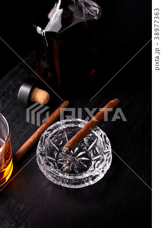 Glass of whiskey with smoking cigar. Glass of whiskey with smoking cigar. 38977363