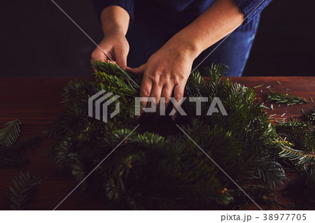 Florist makes a traditional Christmas wreath Florist makes a traditional Christmas wreath 38977705