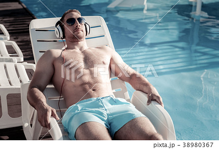 Well built gentleman sunbathing while lying on Well built gentleman sunbathing while lying on 38980367