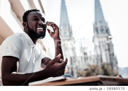 Extremely happy young man laughing while talking 38980570