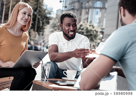Cheerful colleagues discussing contract together Cheerful colleagues discussing contract together 38980998