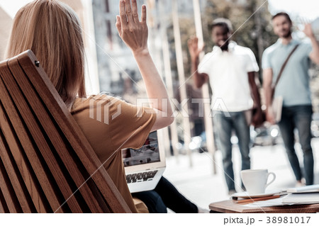 Female entrepreneur waving to her colleagues 38981017