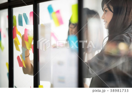 Businesspeople putting their ideas at sticky notes 38981733