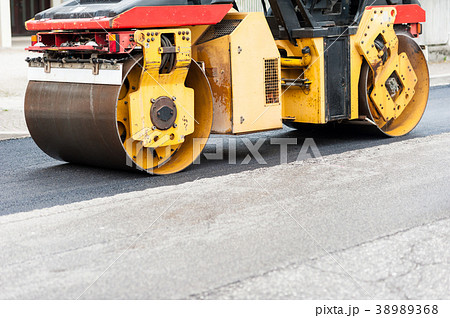 Road roller at work. Work of asphalting a road. Road roller at work. Work of asphalting a road. 38989368
