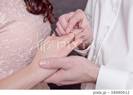 Close-up male and female hands while putting a 38990012