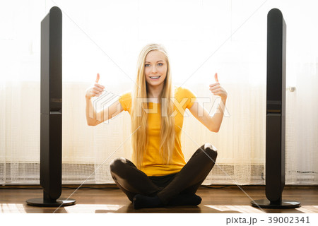 Woman next to speakers at home Woman next to speakers at home 39002341