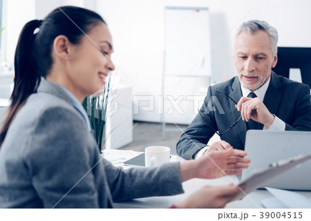 Mature boss talking with cheerful office worker Mature boss talking with cheerful office worker 39004515