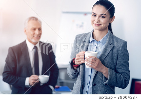 Beautiful young employee posing with cup of coffee 39004537