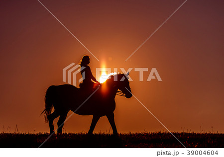 Woman riding a horse at sunset 39004604