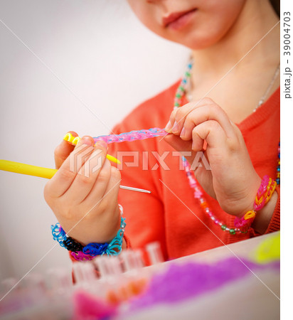 Girl weaves jewelry bracelet gum, gum weaving Girl weaves jewelry bracelet gum, gum weaving 39004703