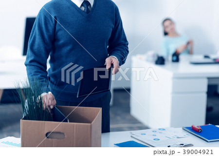 Close up of mature man packing office supplies in Close up of mature man packing office supplies in 39004921
