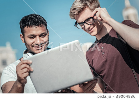 Pleasant smart students looking at the laptop 39004936
