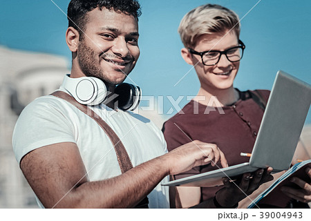 Handsome cheerful man wearing holding a laptop 39004943
