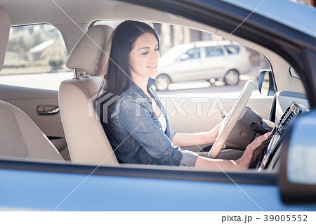 Confident pleasant woman sitting and setting up Confident pleasant woman sitting and setting up 39005552