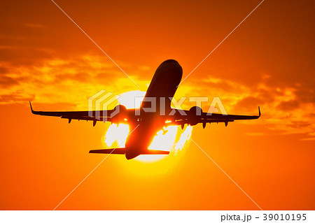 真っ赤に映える夕焼け空を背景に飛行機風景 39010195