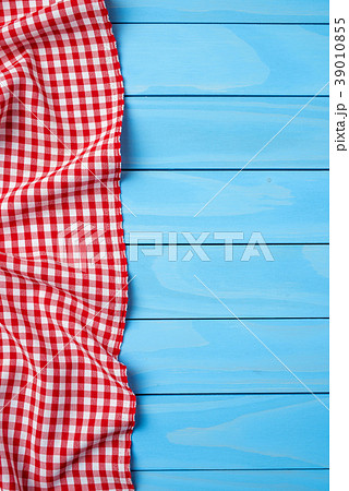 Red folded tablecloth over blue wooden table 39010855