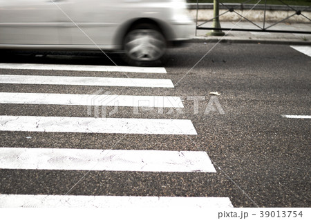 Pedestrian crossing with unfocused car in the background 39013754