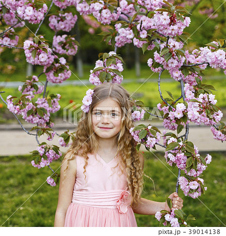 Beautiful little girl in blossom cherry garden Beautiful little girl in blossom cherry garden 39014138