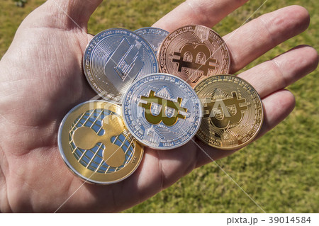 Cryptocurrency coins hand, Bitcoin, Ripple, Dash Cryptocurrency coins hand, Bitcoin, Ripple, Dash 39014584