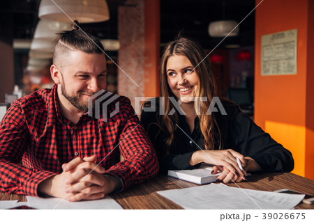 Man and woman sitting in cafe together, business Man and woman sitting in cafe together, business 39026675