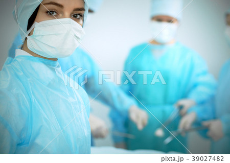 Medical team in masks performing operation. Focus Medical team in masks performing operation. Focus 39027482