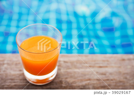 Relaxation with Orange Juice at the Poolside 39029167