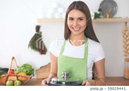 Young happy woman cooking in the kitchen. Healthy Young happy woman cooking in the kitchen. Healthy 39029441