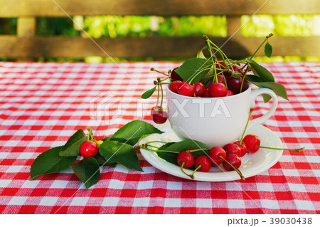 Cherries with leaves in the beautiful white cup Cherries with leaves in the beautiful white cup 39030438
