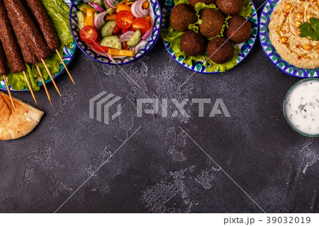 Classic kebabs, falafel and hummus on the plates. 39032019