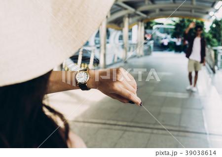 A girl is checking time from her wristwatch A girl is checking time from her wristwatch 39038614