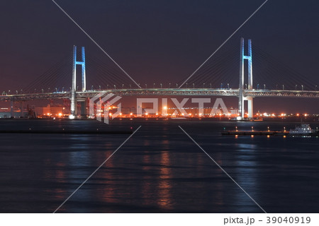 横浜港と青色に点灯した横浜ベイブリッジの夜景の写真素材