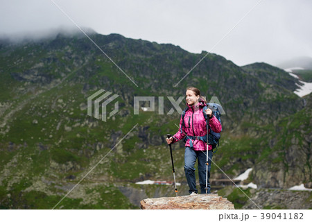 Smiling hiker woman climbing green rocky mountains 39041182