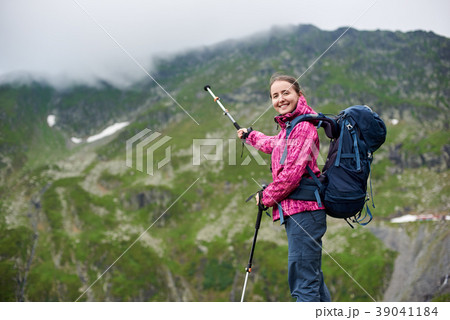 Hiker pointing with a trekking stick on a mountain Hiker pointing with a trekking stick on a mountain 39041184