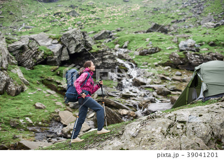 Female sporty climber walking up rocky slope of beautiful foggy mountains in Romania. Female sporty climber walking up rocky slope of beautiful foggy mountains in Romania. 39041201