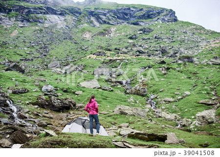 Woman on rocky slope enjoying view hills Woman on rocky slope enjoying view hills 39041508